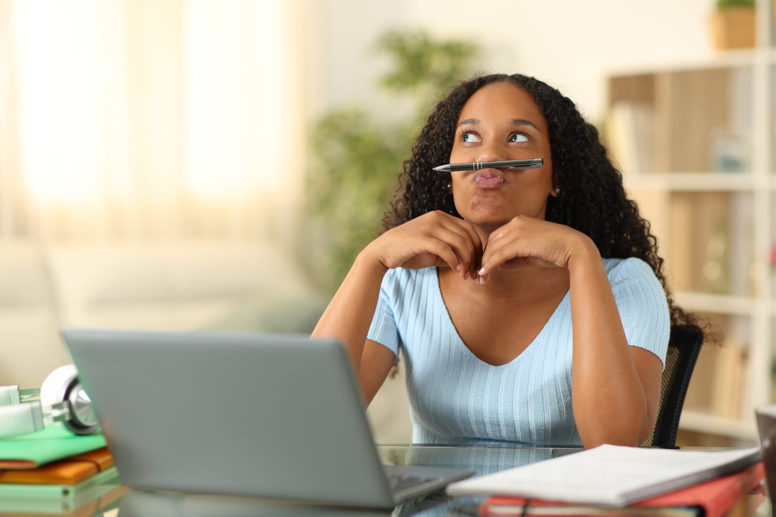 Person thinking at a desk with a laptop
